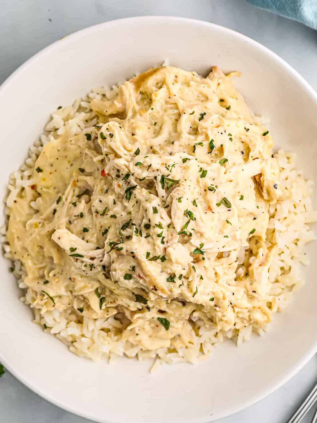 white bowl filled with rice and crockpot italian chicken