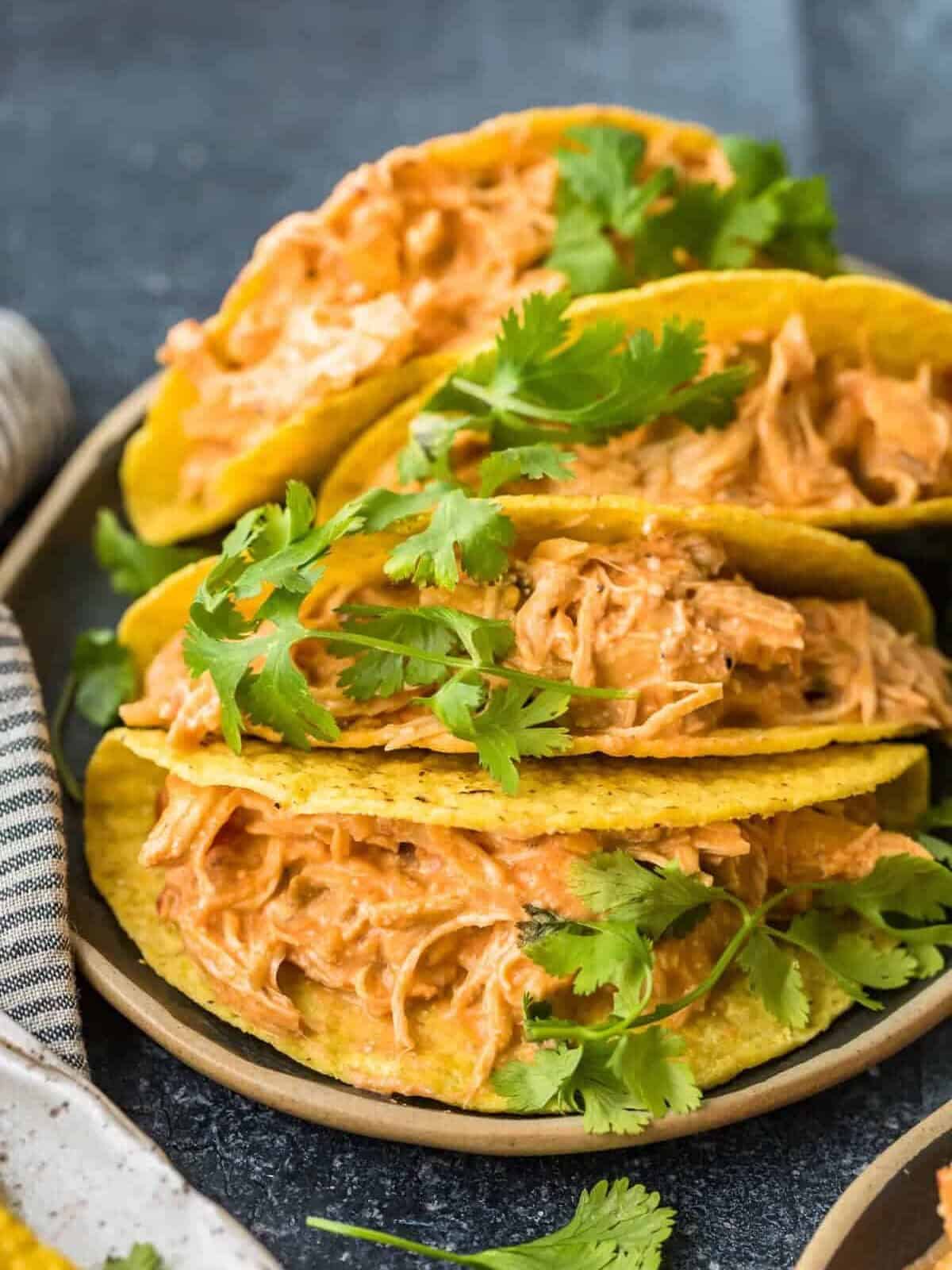 Four chicken tacos on a serving plate