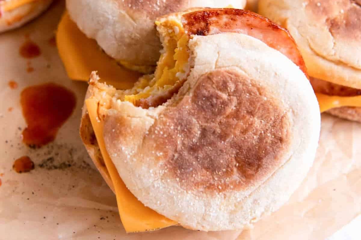 a bitten egg mcmuffin leaning up against another.