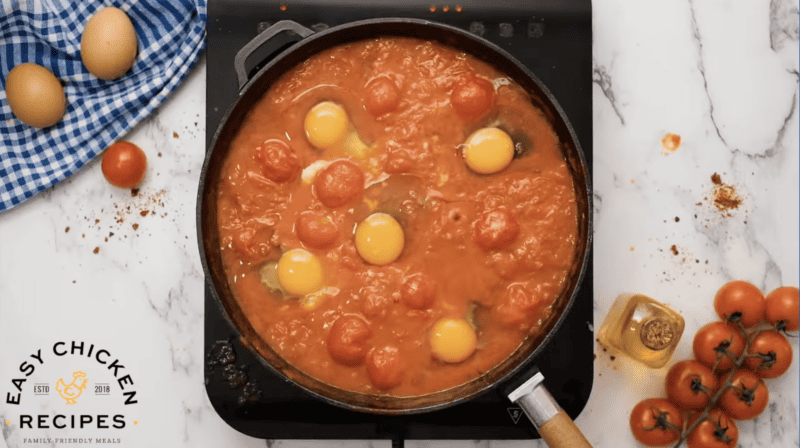 Simple chicken shakshuka recipe with tomatoes and eggs cooked in a pan.