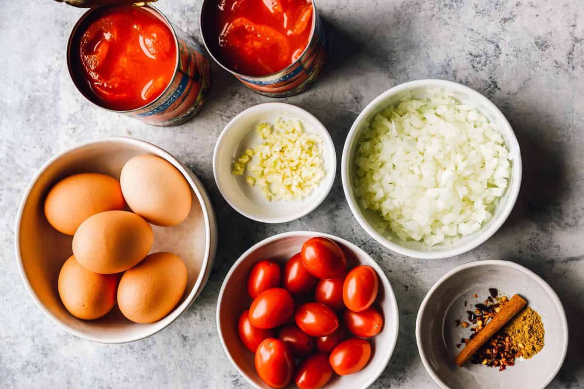 overhead view of ingredients for shakshuka in individual bowls.