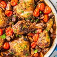 A pan with chicken and mushrooms in it.