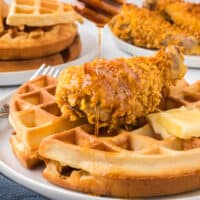Chicken fried waffles with honey drizzled over them.