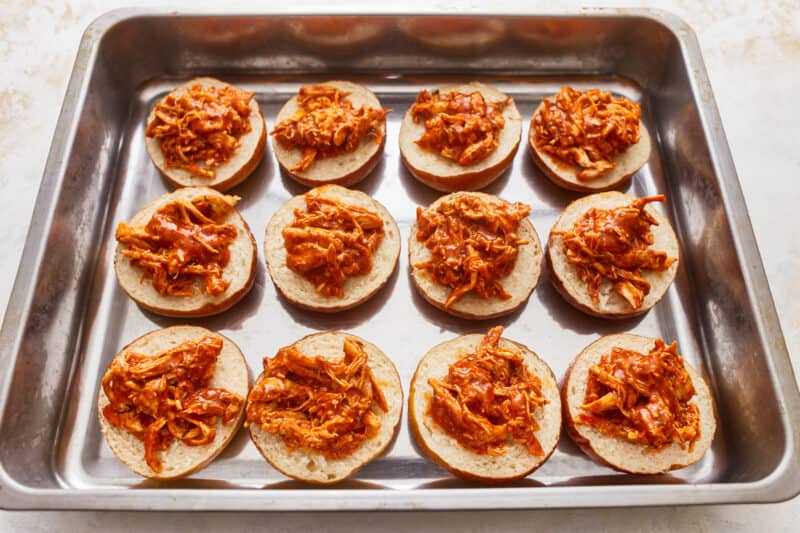 Bbq pulled pork sandwiches on a baking sheet.
