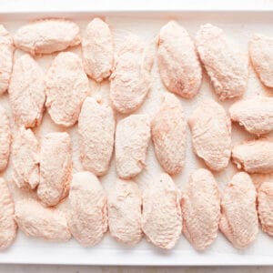 Frozen chicken breasts on a baking sheet.