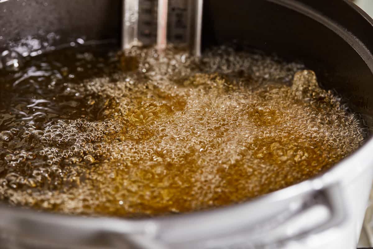 A pot of brown liquid with a thermometer in it.