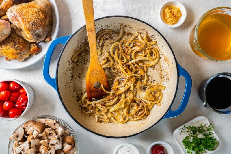 A pan with onions, mushrooms, tomatoes and other ingredients.