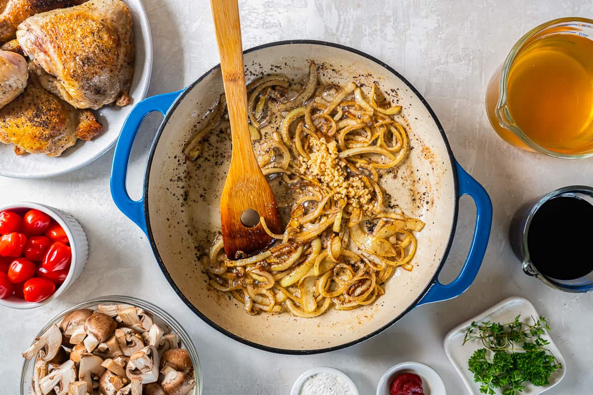 A pan with onions, mushrooms, tomatoes and other ingredients.