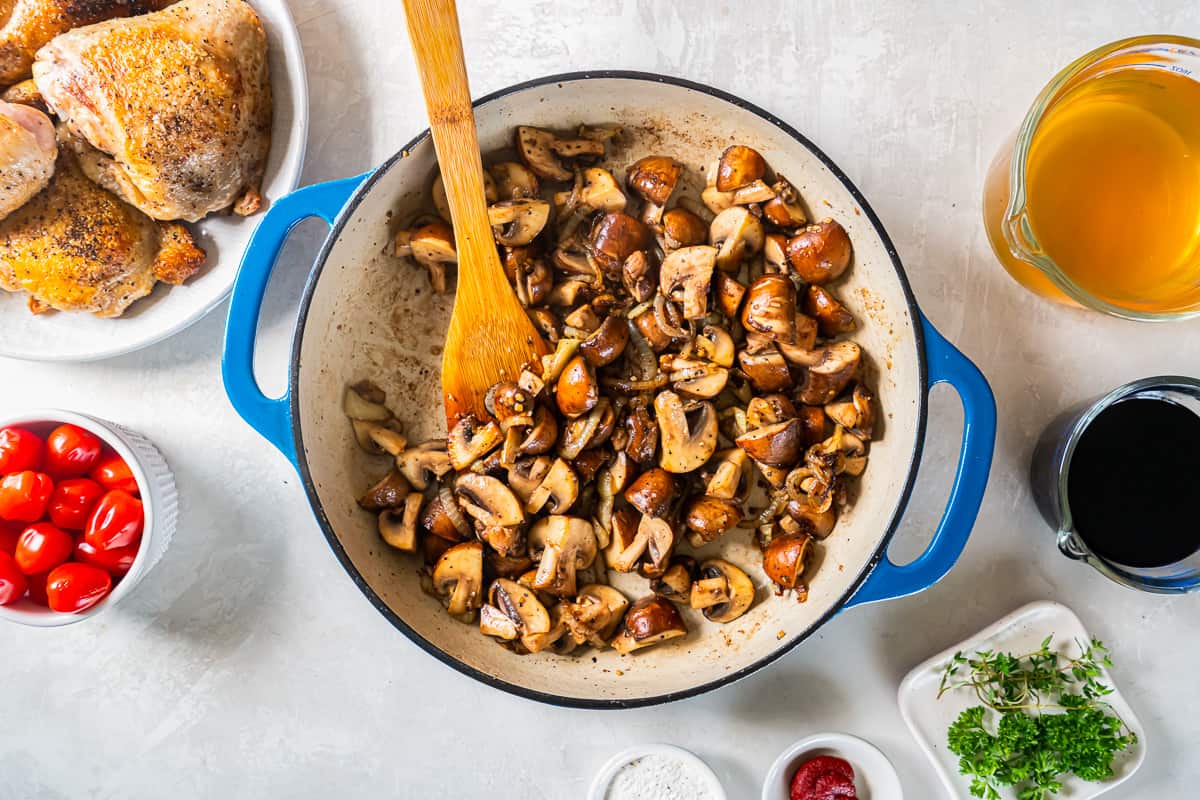 A pan with mushrooms, tomatoes, and other ingredients.