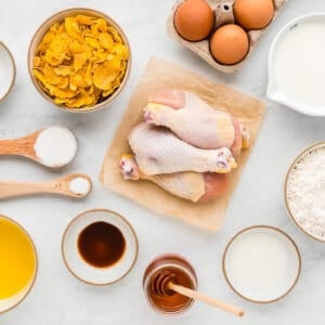 Chicken, eggs, flour and other ingredients on a white background.