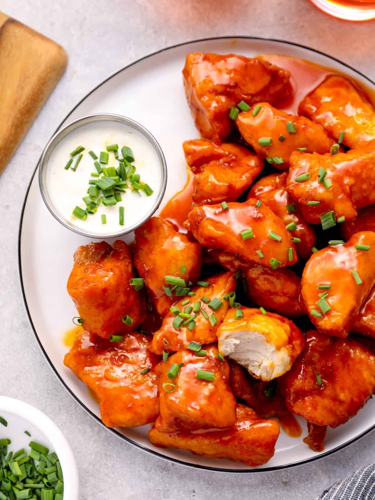 a plate of boneless chicken wings with buffalo sauce