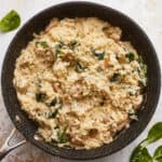 Risotto with spinach and mushrooms in a skillet.