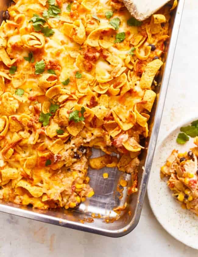 Mexican lasagna in a baking dish with a slice of bread.