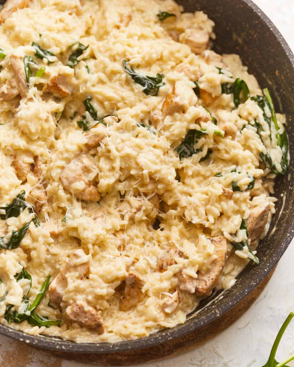 Risotto with chicken and spinach in a skillet.