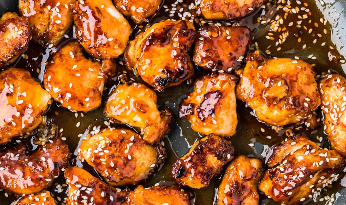 Asian chicken in a skillet with sesame seeds.
