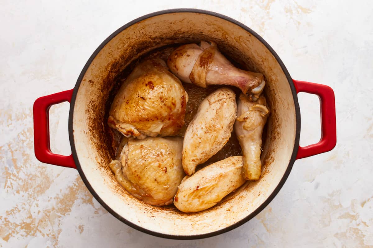 Chicken in a red pot on a white background.