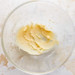 Butter in a glass bowl on a white background.