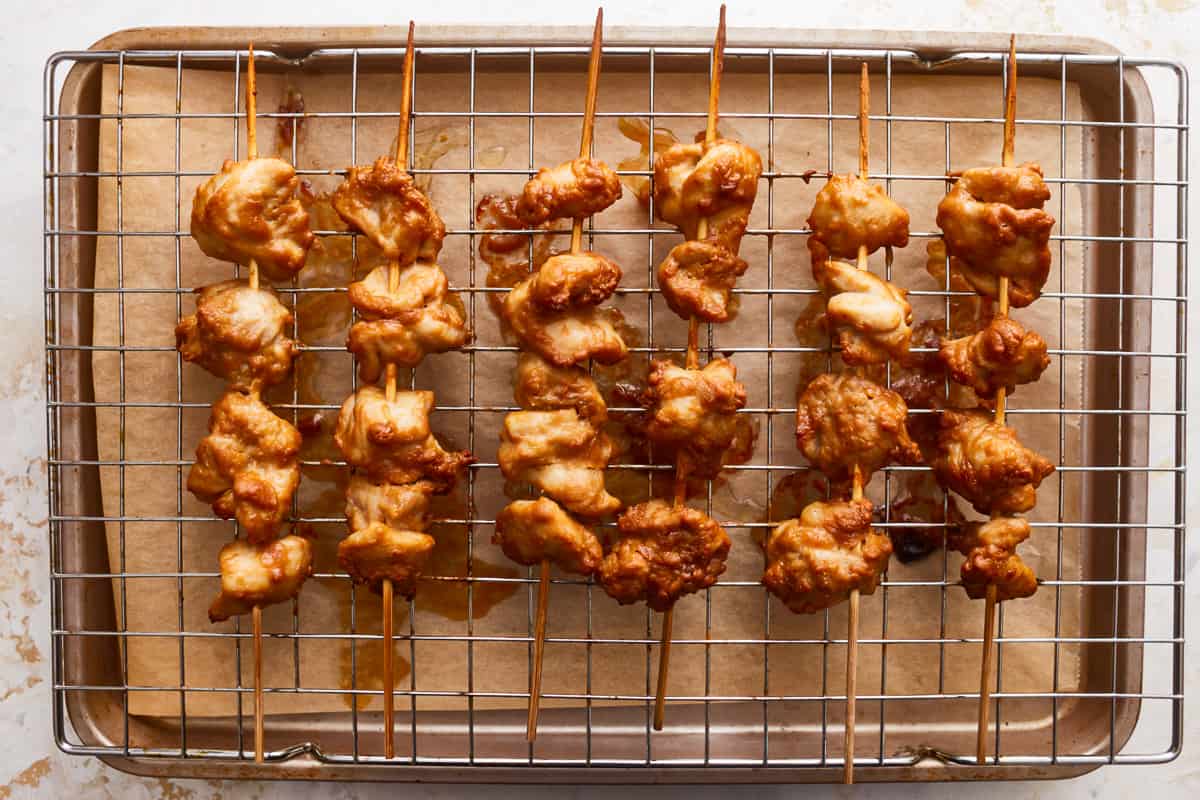 Chicken skewers on a baking sheet.