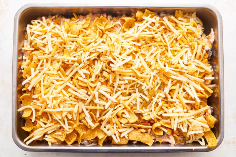 A baking dish filled with nachos and cheese.