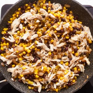 Chicken and corn in a frying pan.