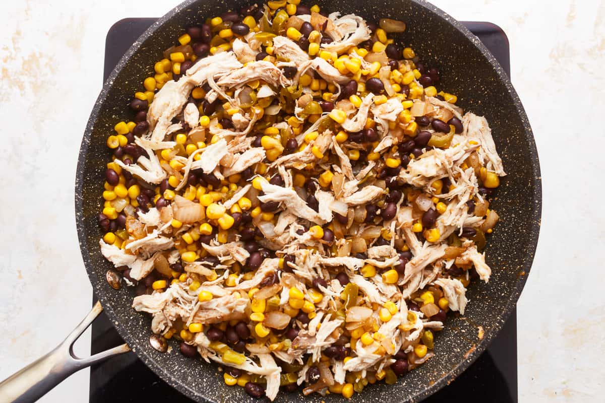 Chicken and corn in a frying pan.