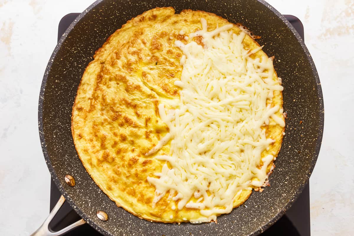 An omelet with cheese in a skillet.