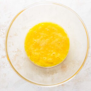 A glass bowl with a yellow liquid in it.