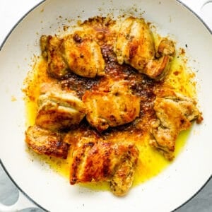 Roasted chicken in a white dish with spices.
