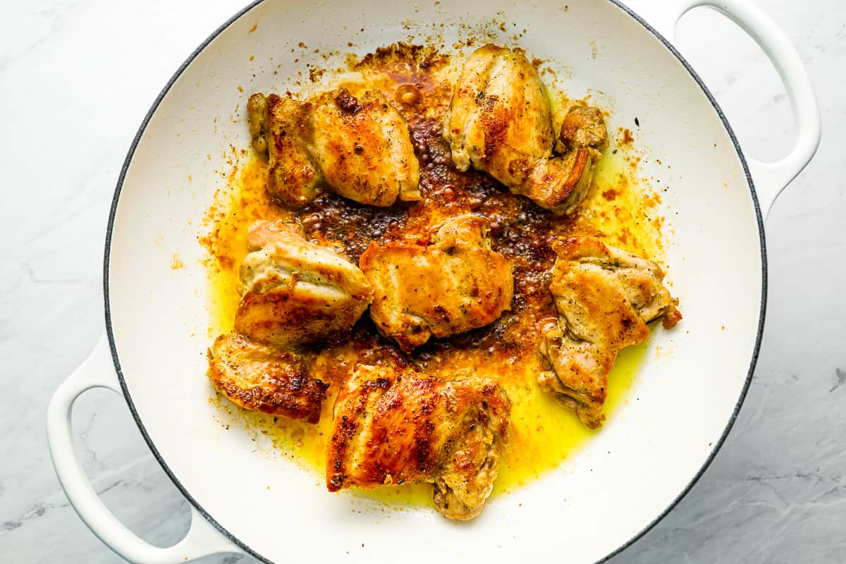 Roasted chicken in a white dish with spices.