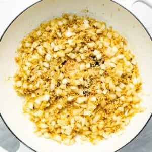 A white pan filled with a mixture of onions and garlic.
