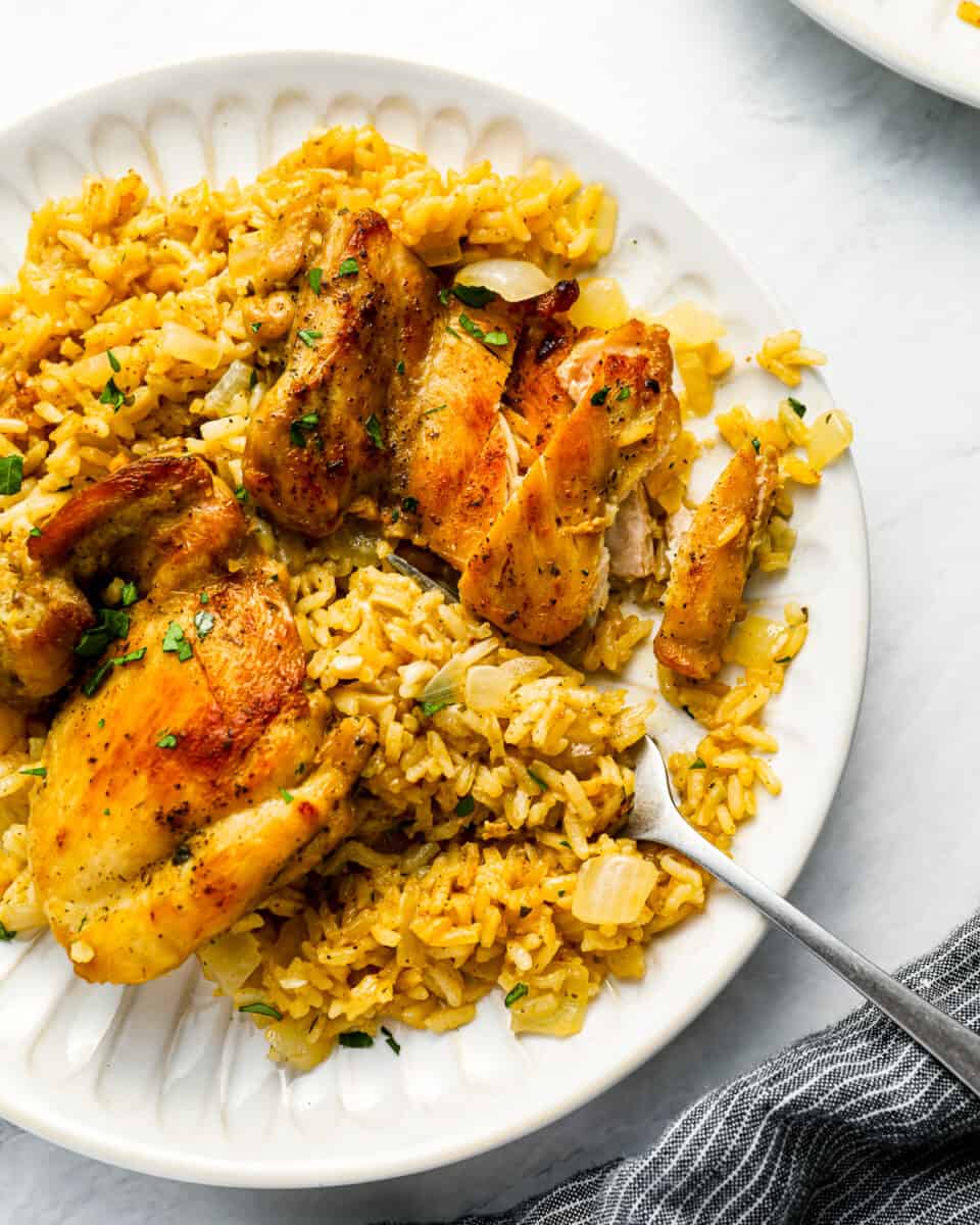 A plate with chicken and rice on it.