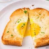 egg in a hole cut in half on a plate