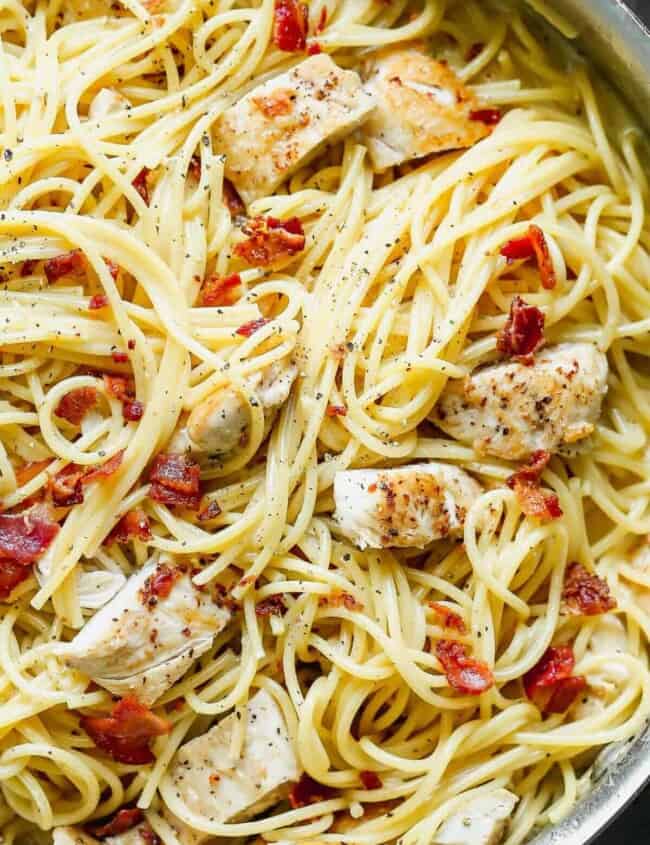 up close image of pasta with cream sauce, bacon, and chicken