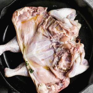 whole chicken flattened in skillet