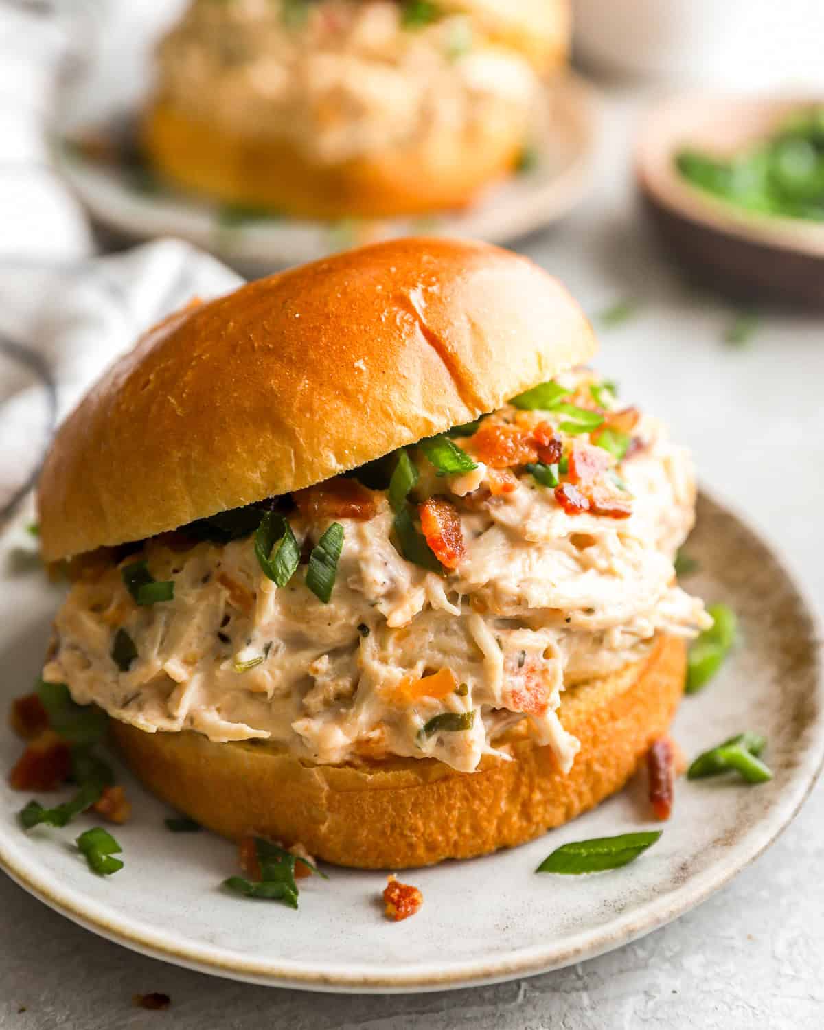 a serving of crockpot crack chicken on a hamburger bun.