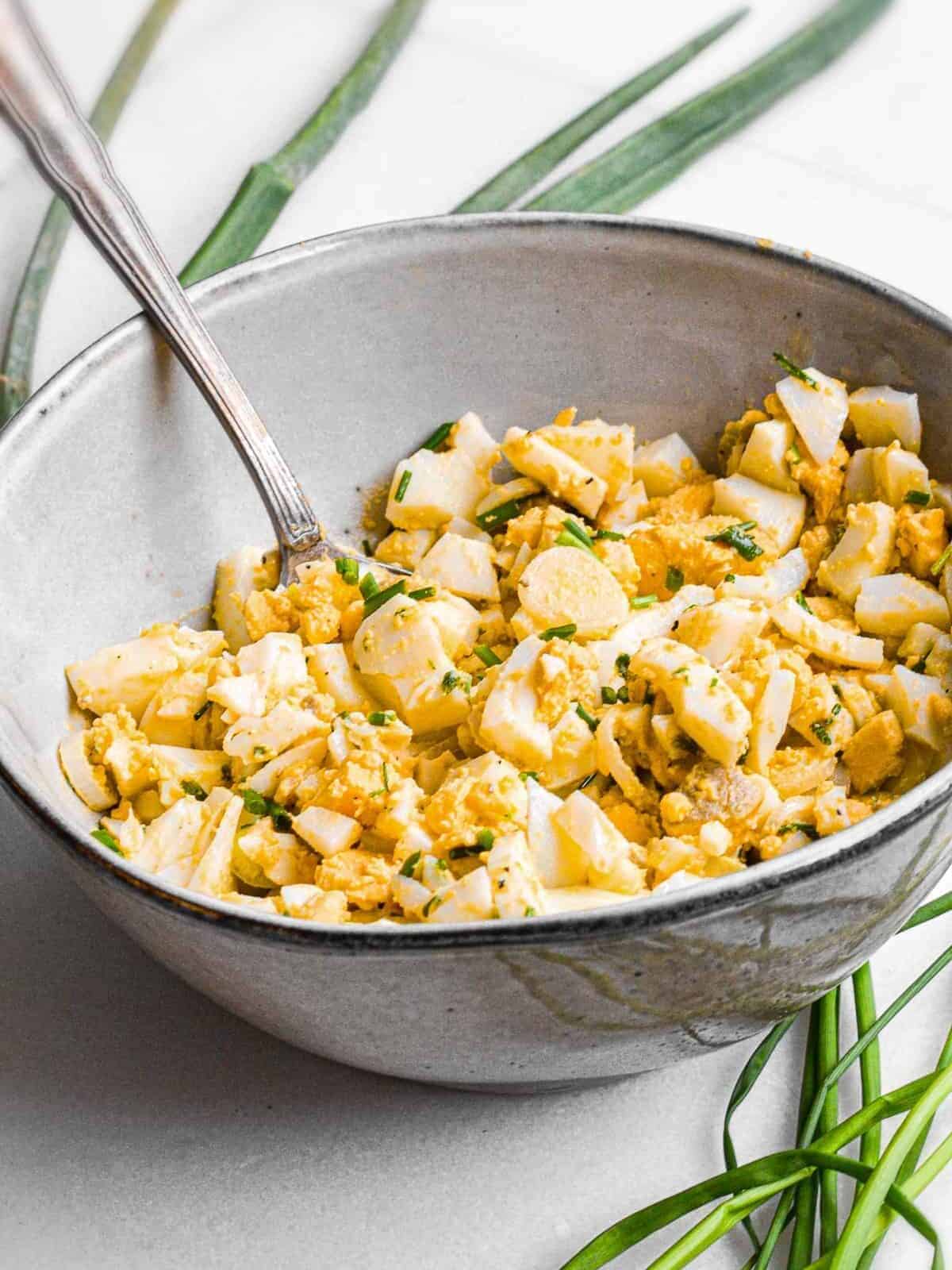Homemade egg salad in a bowl with a spoon