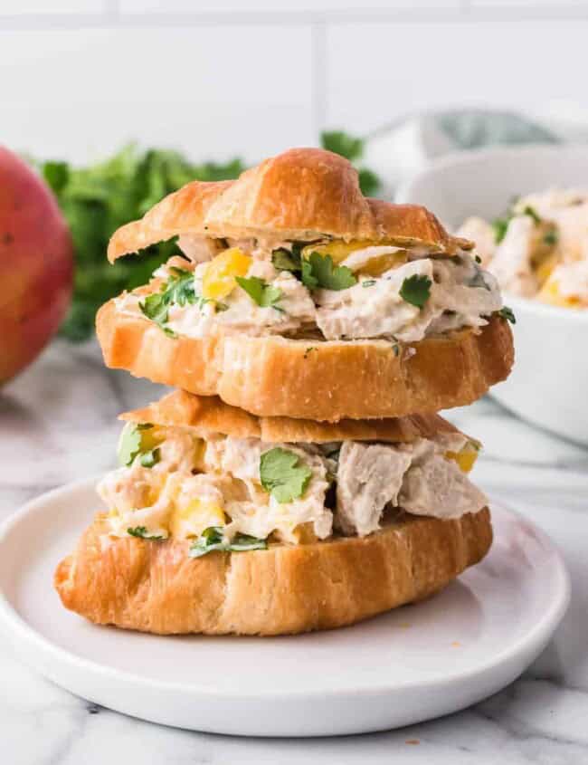 two stacked croissants filled with chicken salad with mango