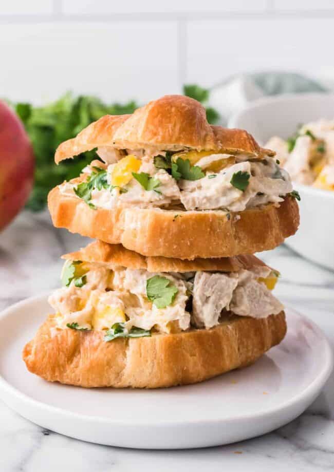 two stacked croissants filled with chicken salad with mango