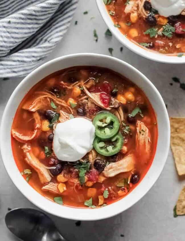 Mexican chicken soup with sour cream and tortilla chips, reminiscent of Chicken Enchilada Soup.