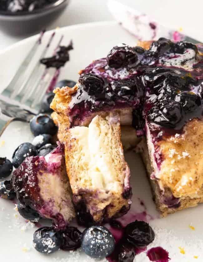 french toast stuffed with cream cheese on plate with blueberry sauce