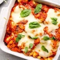 white pan with chicken parm gnocchi bake topped with fresh basil