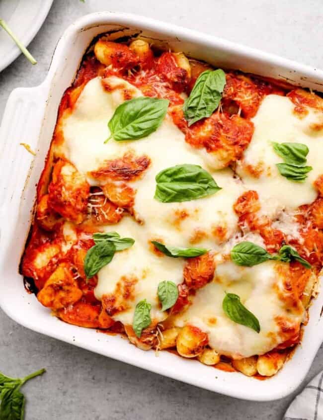 white pan with chicken parm gnocchi bake topped with fresh basil