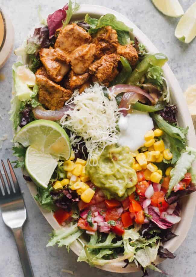 chipotle mexican chicken salad with toppings in bowl