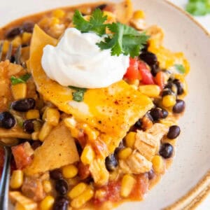 a serving of cowboy chicken casserole on a plate, topped with sour cream.