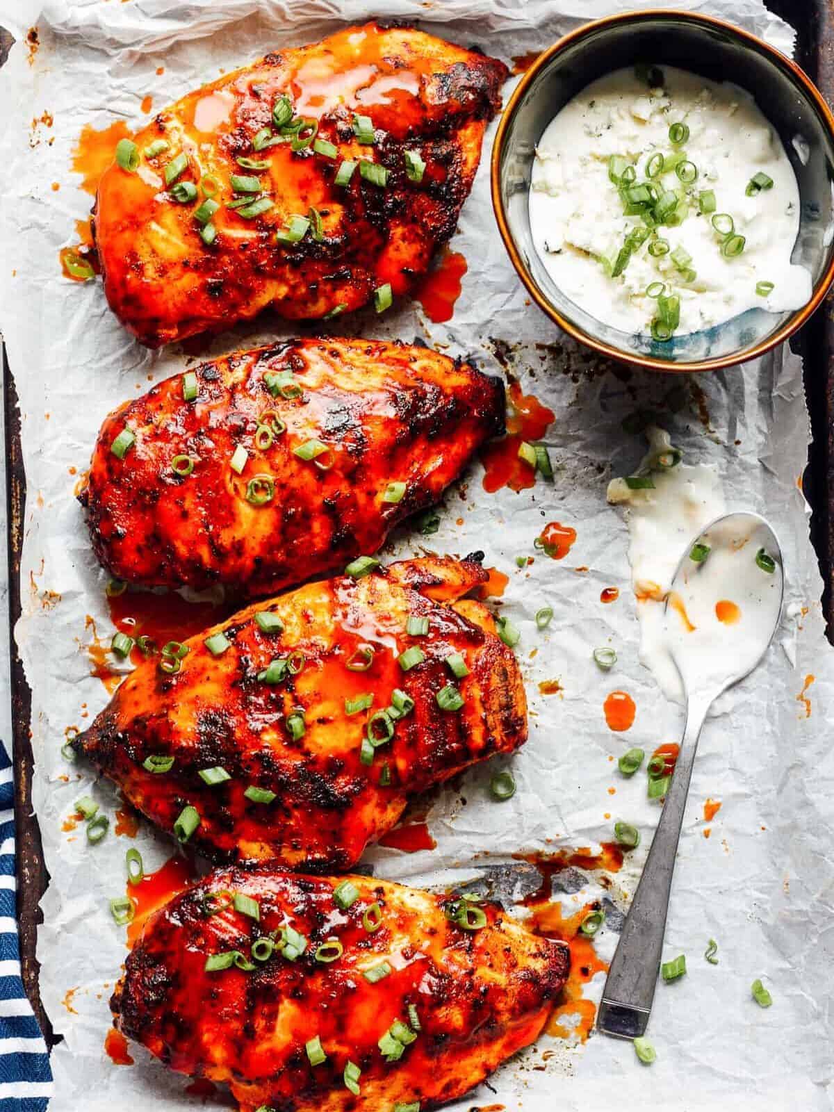 grilled buffalo chicken on parchment paper with ranch