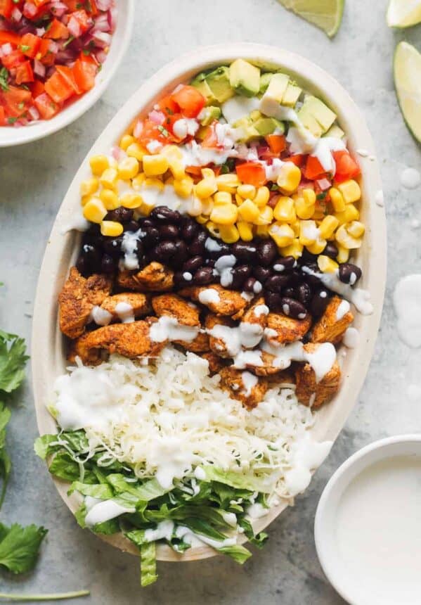 layered chicken burrito bowl next to ingredients