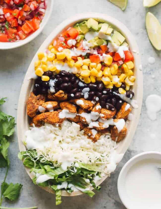 layered chicken burrito bowl next to ingredients