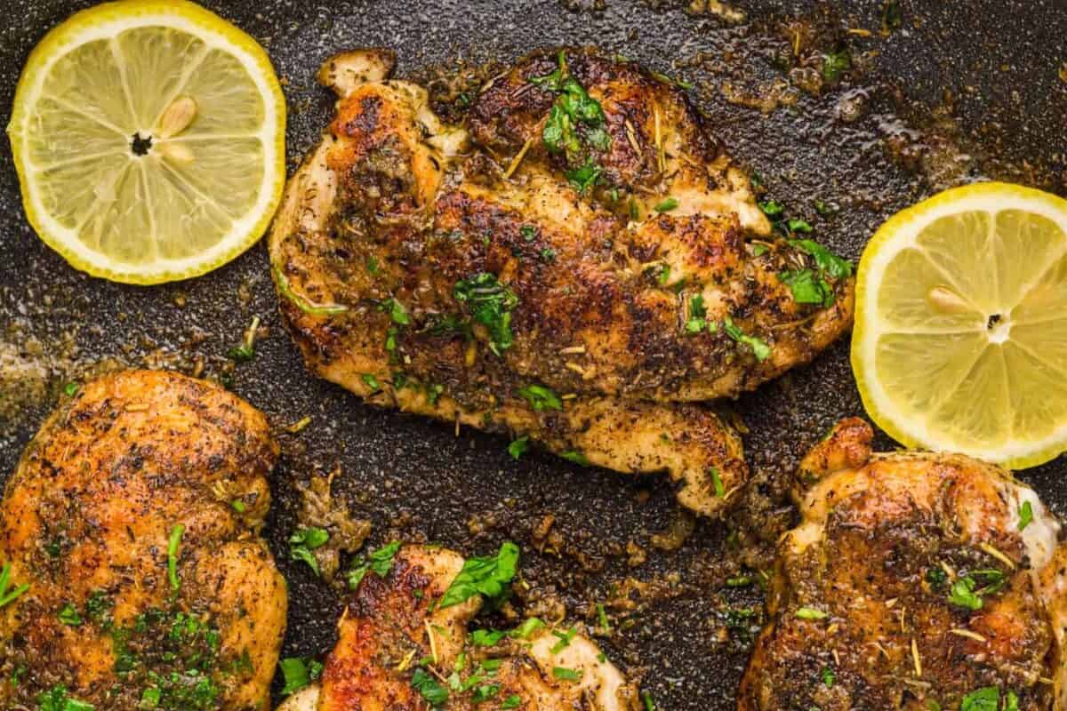 close up of lemon pepper chicken breasts in a skillet.