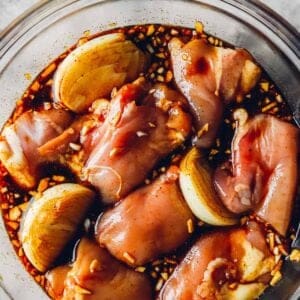 a clear bowl filled with chicken and balsamic marinade