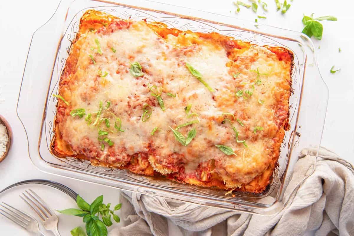 overhead view of chicken parmesan lasagna in a glass baking dish.